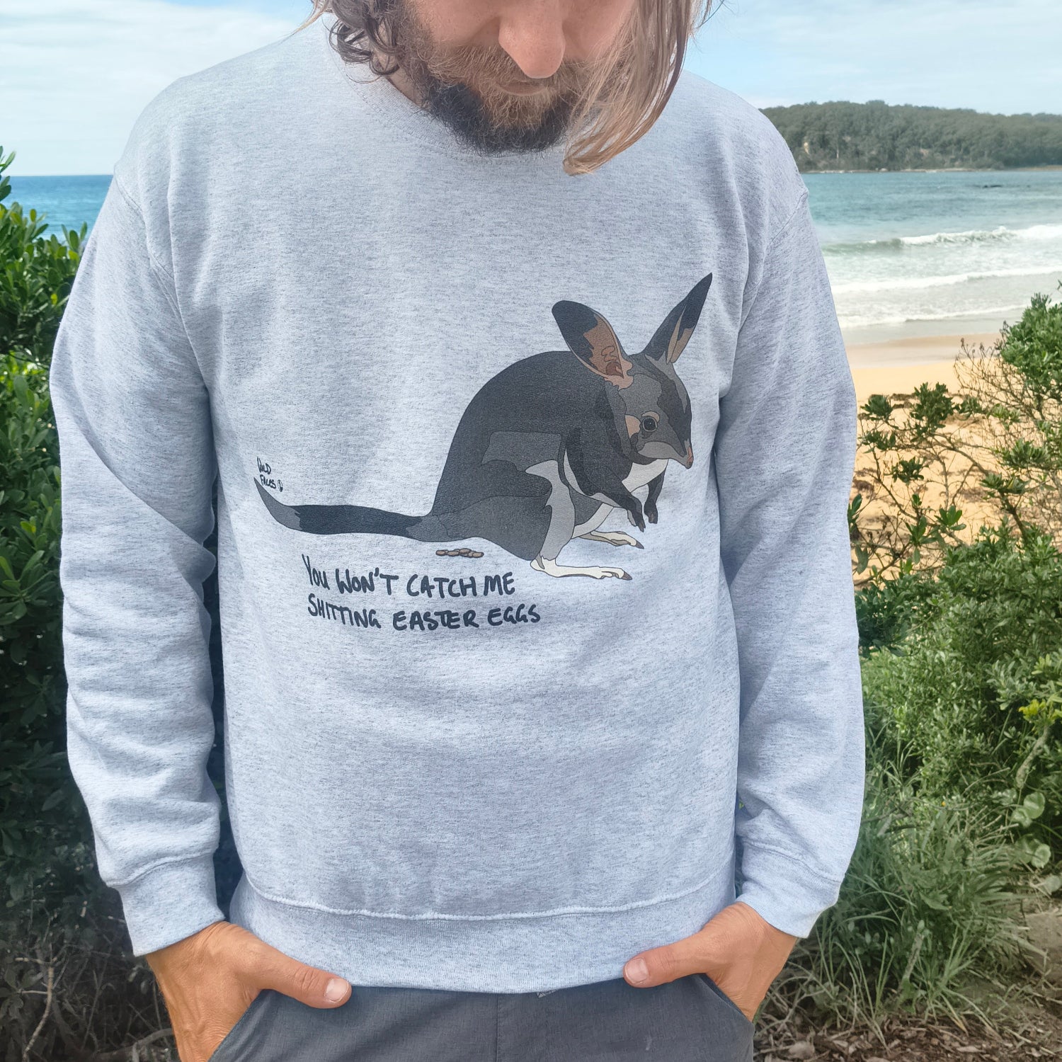 Person wearing a gray sweatshirt with a bilby design outdoors